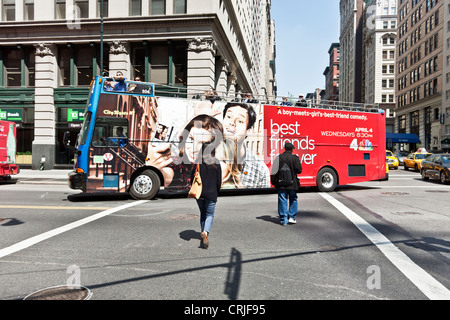 tour bus with advertisement for short lived television show turns onto 14th street on a beautiful spring day New York City Stock Photo