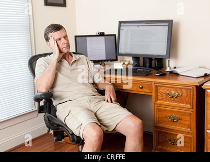 Self-employed man working from home office looking worried / stressed Stock Photo