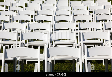 Rows of formal white wooden wedding chairs set up for a wedding or concert Stock Photo