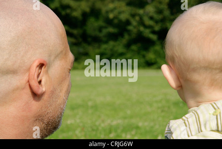 grandfather and grandson looking across a meadow at a close forest, Germany Stock Photo