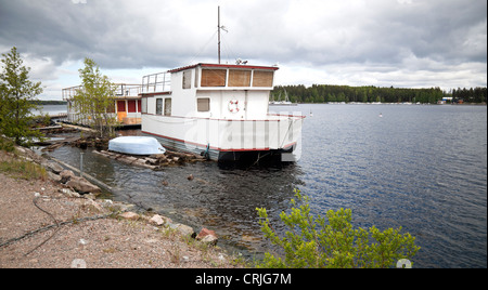 Small white boat moored on lake in Imatra town, Finland Stock Photo