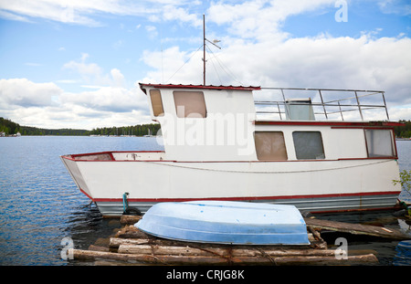 Small white boat moored on lake in Imatra town, Finland Stock Photo