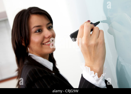 business woman going to write something on a wall panel in the office Stock Photo