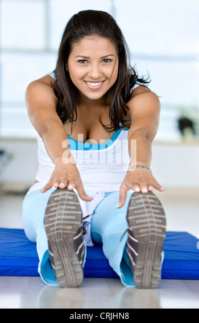 woman doing stretching exercises on the floor at the gym Stock Photo