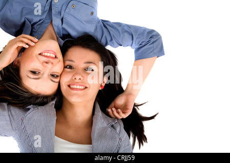 beautiful sisters lying head to head on the ground Stock Photo
