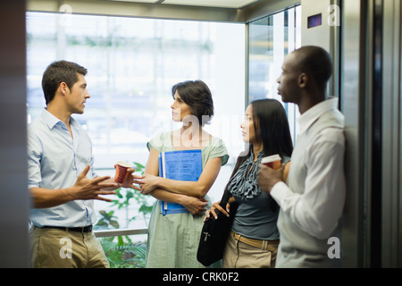 Business people riding glass elevator Stock Photo