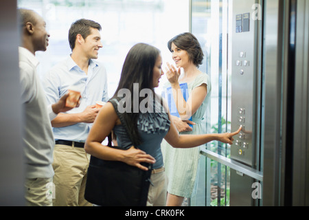 Business people riding glass elevator Stock Photo