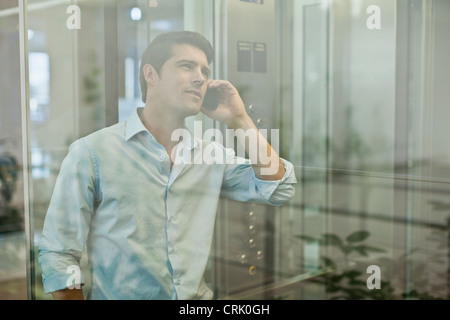 Businessman on cell phone in elevator Stock Photo
