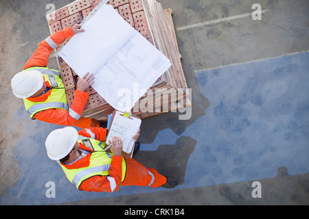 Workers reading blueprints on site Stock Photo