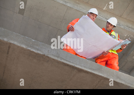 Workers reading blueprints on site Stock Photo