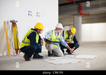 Workers reading blueprints on site Stock Photo