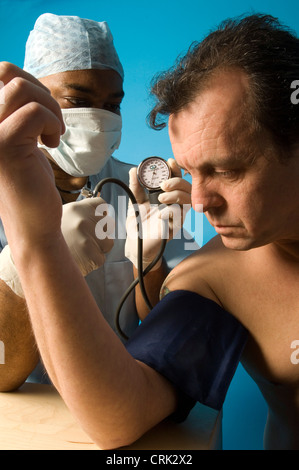 A middle-aged man has his blood pressure measured by a doctor using a sphygmomanometer. Stock Photo