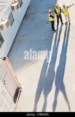 Workers casting shadows on site Stock Photo