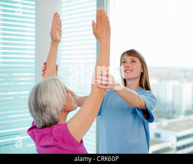 Doctor examining womans arms in office Stock Photo