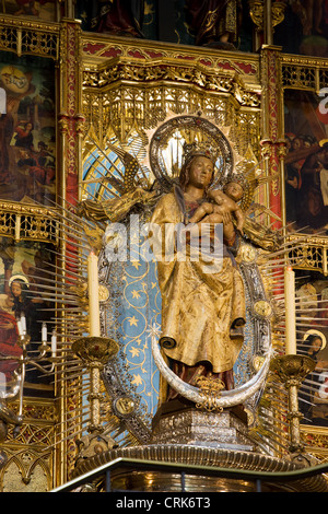 Ornate altar with sculptures of Blessed Virgin Mary with Baby Jesus in Almudena Cathedral, Madrid, Spain. Stock Photo