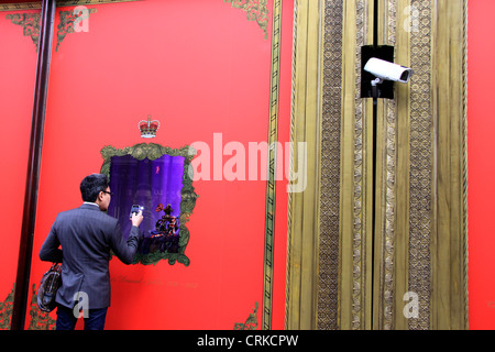 Man taking a picture of the Harrods Queens Jubilee window display Stock Photo