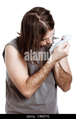 Bizarre psycho artist man holding mask, isolated on white background. Stock Photo