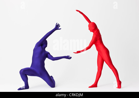 Couple in bodysuits with invisible globe Stock Photo