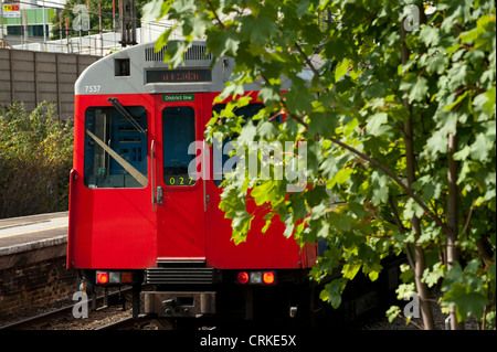 A London Underground train on the district line approaching a railway station in London, England. Stock Photo
