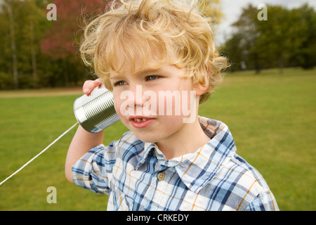 Boy playing with tin can telephone Stock Photo