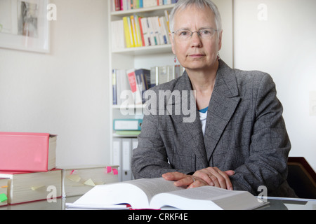 Lawyer reading text book in office Stock Photo