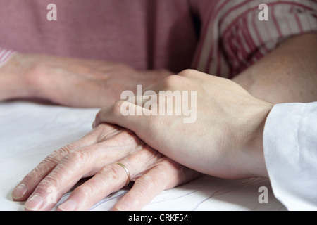 Doctor holding older womans hand Stock Photo