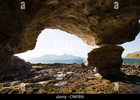 A sea cave near the Bay of Laig at Cleadale on the Isle of Eigg, looking towards the Isle of Rhum, Scotland, UK. Stock Photo