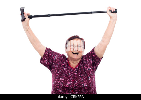 Happy laughing elderly woman holding walking stick, isolated on white background. Stock Photo