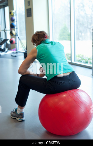 Woman using exercise ball in gym Stock Photo
