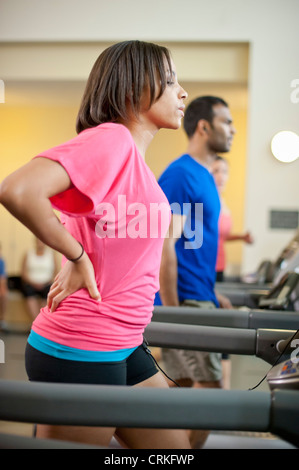 Woman using treadmill in gym Stock Photo