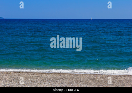 Summer day at the beach in front of the blue sea and sky Stock Photo