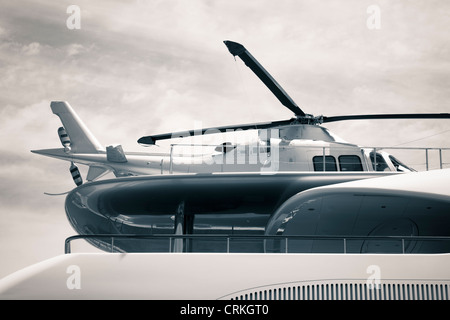 Detail of luxury yacht with helicopter on the deck, digitally retouched and toned photo. Stock Photo