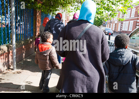 Muslim mothers picking their children up from infant school in Queens Park, London, UK. Stock Photo