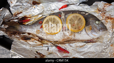 cooked gilthead sea bream with lemon, garlic, and chili Stock Photo