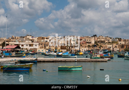 Traditional Maltese fishing boats (luzzu) moored in the harbour in the quiet fishing village of Marsaxlokk, Malta Stock Photo