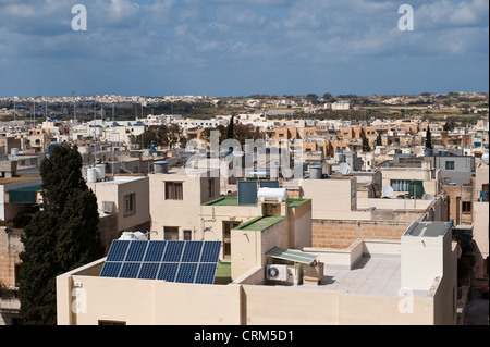 A rooftop view of Zejtun, Malta, shows many houses with both passive solar water heaters and photo-voltaic solar panels for generating electricity Stock Photo