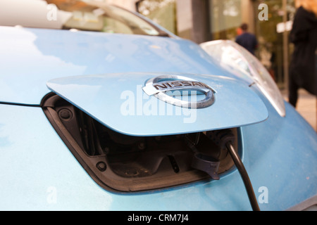 An electric Nissan Leaf vehicle at a recharging station on the street in Berkeley Square, London, UK. Stock Photo