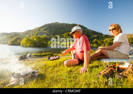 A couple enjoying a barbeque on the shores of Rydal Water in the Lake District, UK. Stock Photo