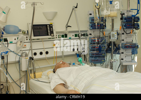 An elderly woman patient under intensive care on a life support system. Stock Photo