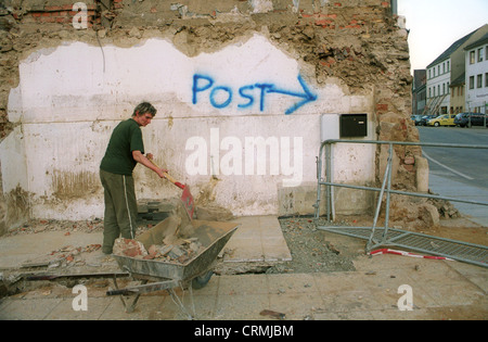 Woman sweeping the remnants of their home together after the flood in Grimsby (Saxony) Stock Photo