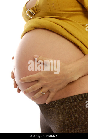 An 8 month pregnant woman holding her stomach Stock Photo