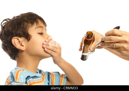 A young boy refusing to take cough syrup from his mother Stock Photo