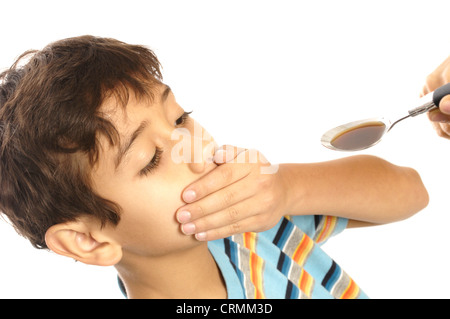 A young boy refusing to take cough syrup from his mother Stock Photo