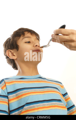 A young boy refusing to take cough syrup from his mother Stock Photo