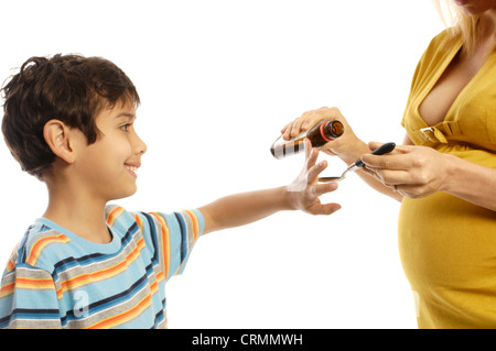 A young boy refusing to take cough syrup from his mother Stock Photo