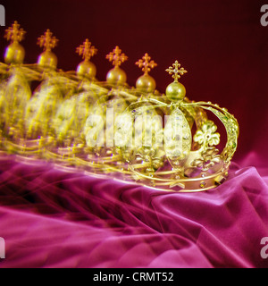 Multiple golden crown on garnet velvet Stock Photo
