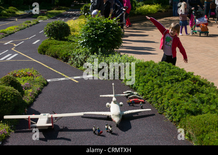 Child mimicking Lego planes at the airport of Miniland, Legoland, Billund, Denmark Stock Photo