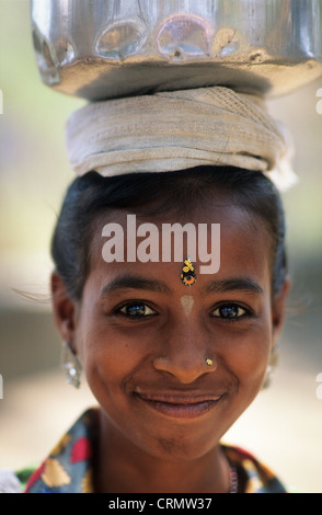 India, Mumbai, Bombay, Portrait of a young girl carrying a water jug on her head. Stock Photo