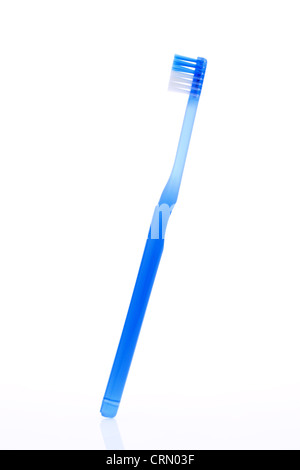 Single new blue handle toothbrush and a tube of toothpaste in plastic ...