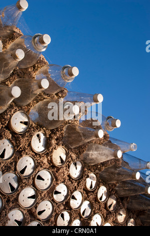 Old beer cans and glass bottles used to build a wall as a background texture Stock Photo